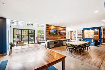 the dining room and living room with a large table and a ping pong